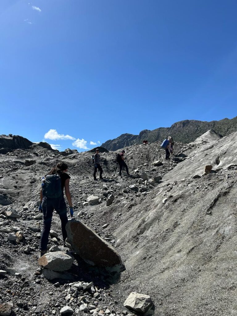Hikers crossing patundas dark glacier section